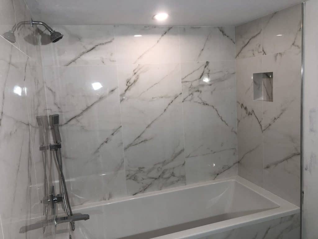 A marble shower and tub in a bathroom.