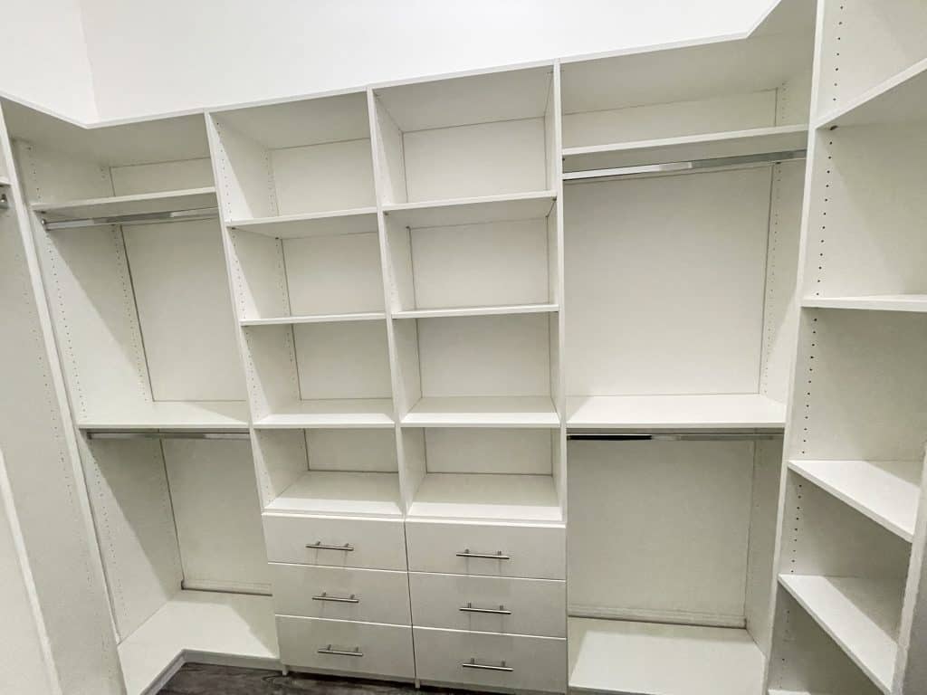 A white walk in closet with drawers and shelves designed for kitchen remodeling.
