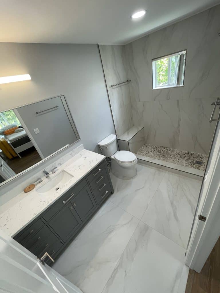 A bathroom with a sink, toilet, and shower, undergoing kitchen remodeling.
